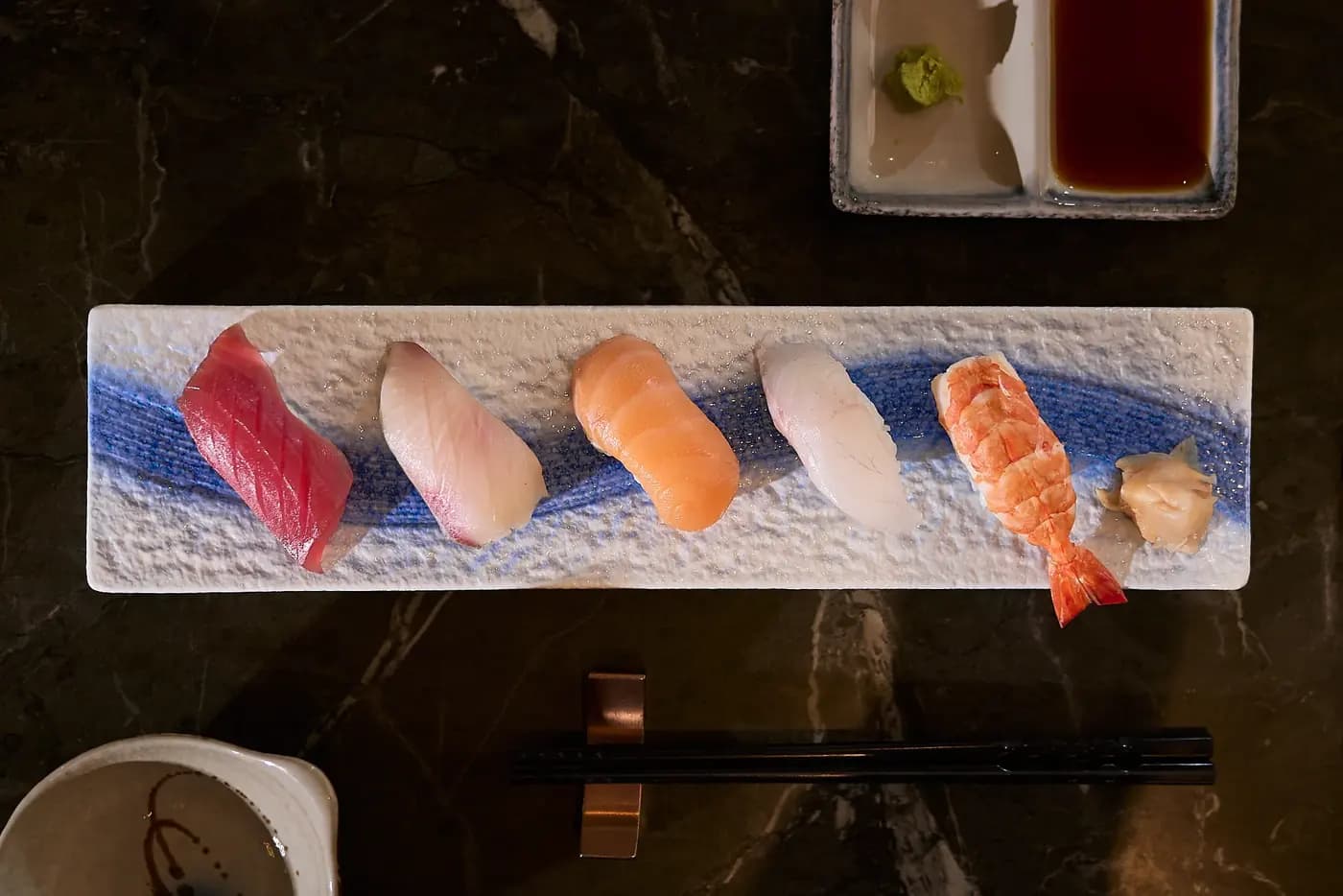 Five pieces of sushi on a blue-and-white tray, Akimitsu Danang