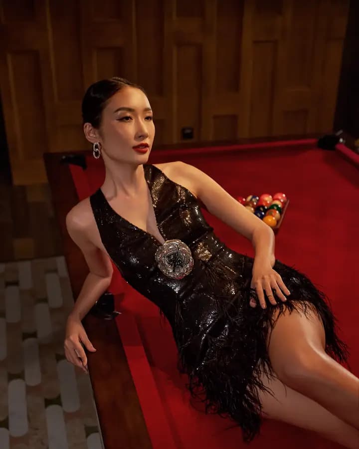 A model in a black dress on a red pool table, XITA x Hoiana